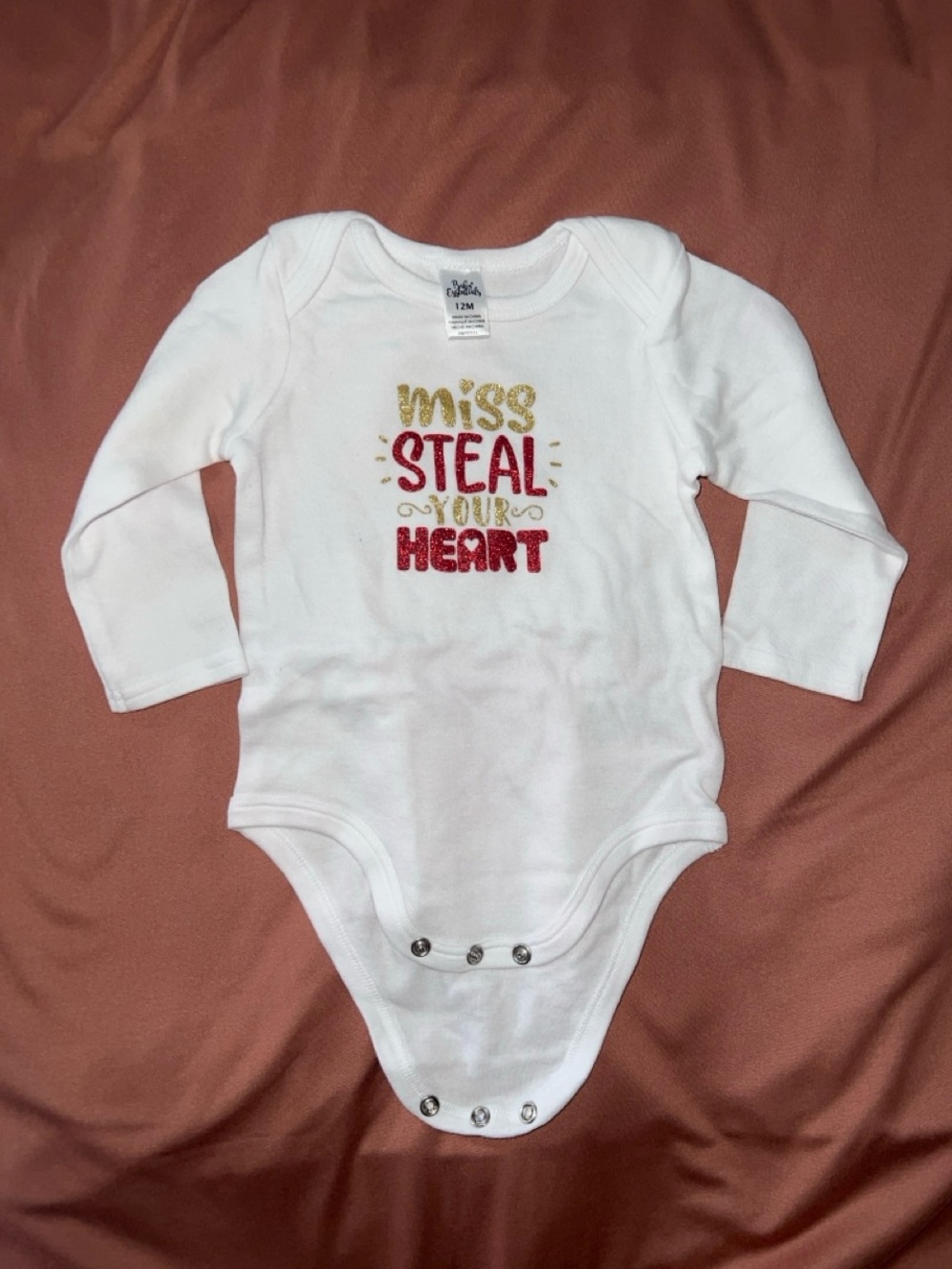 White Long-Sleeve Baby One-Piece with Gold & Red 'Miss Steal Your Heart' Design